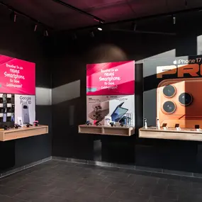 Smartphone-Shop mit Handy-Ausstellung und iPhone Pro Werbeplakat an der Wand