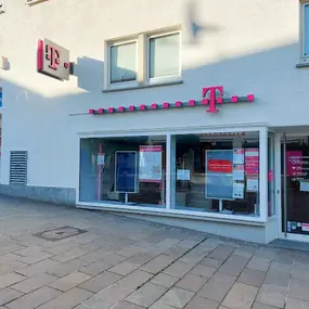 Telekom Shop mit Schaufenster und Werbeplakaten für Mobilfunk und Internet-Tarife.