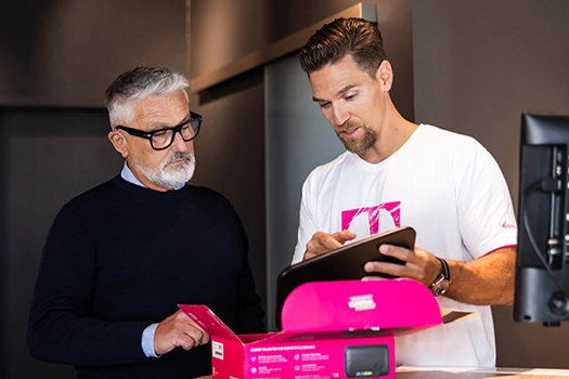 Zwei Männer prüfen Telekom Router im Büro, Beratung zu Internet und WLAN
